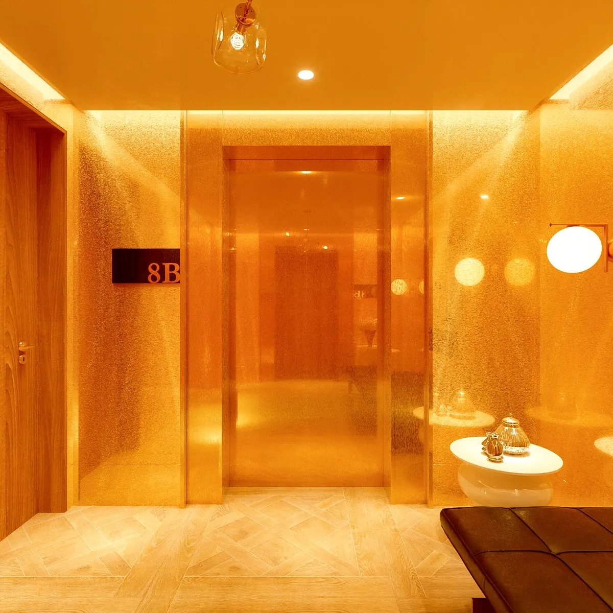 A private lift lobby clad in warm gold panels