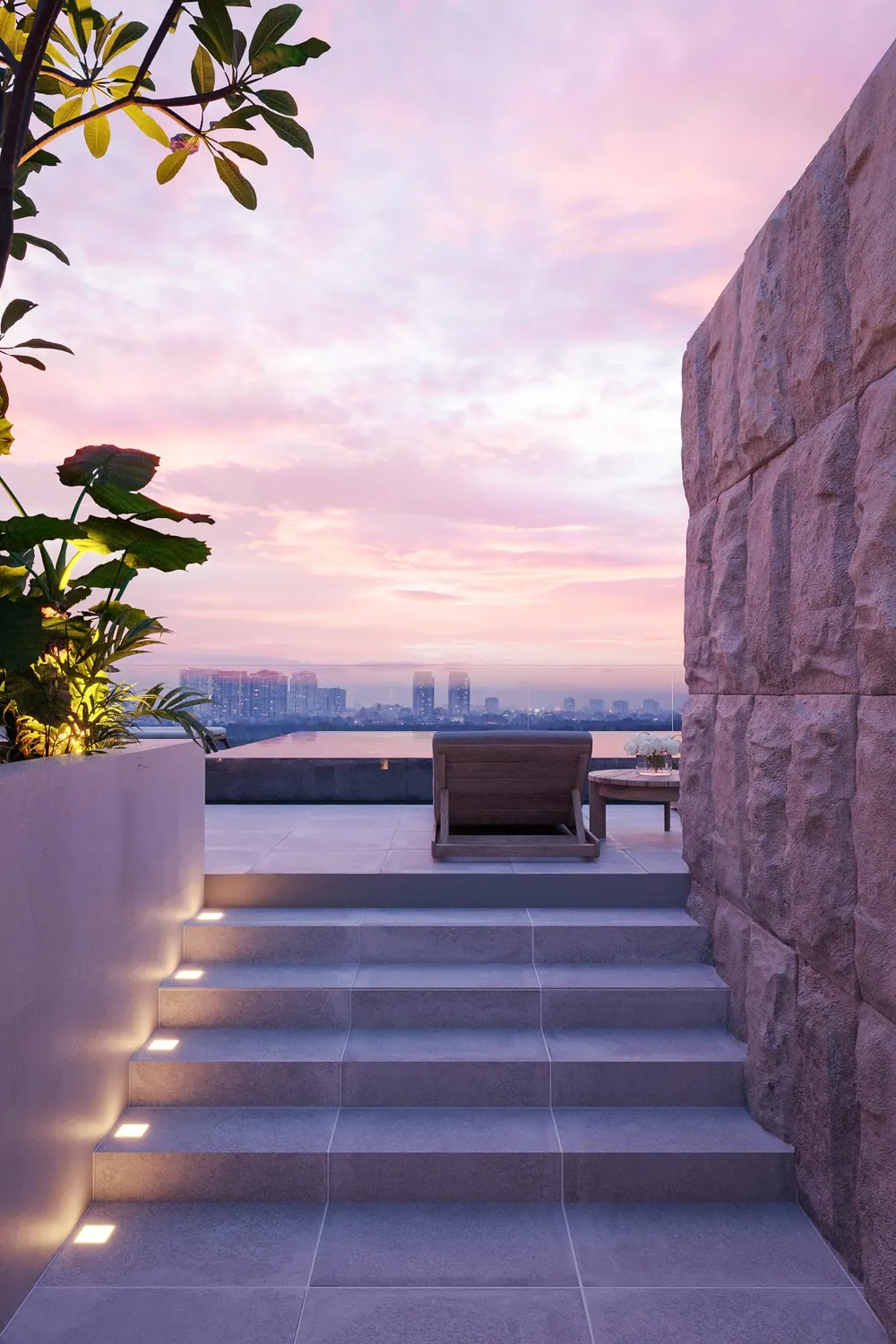 Stone steps rising beside a planted wall at dawn
