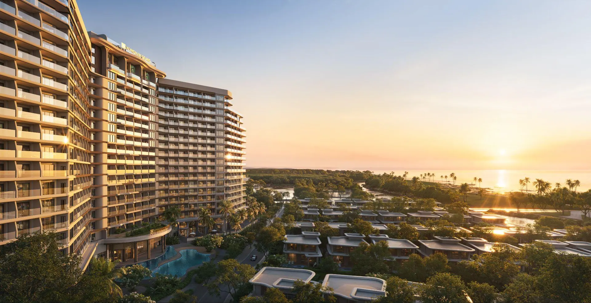 The curved hotel tower at sunset over the villas