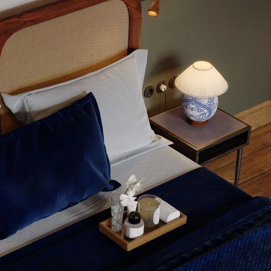 A bedside detail with a ceramic lamp